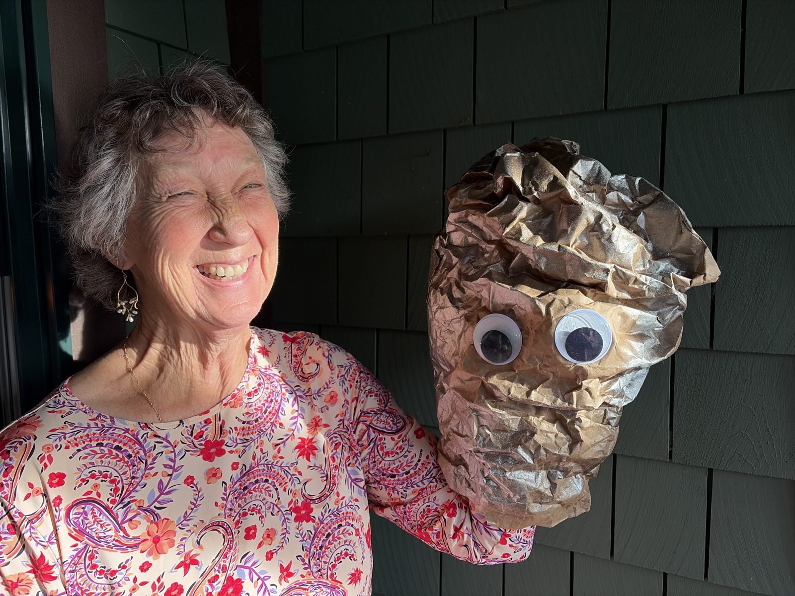 Carrie holding the Igneous rock puppet, a crumpled brown paper bag with large googly eyes
