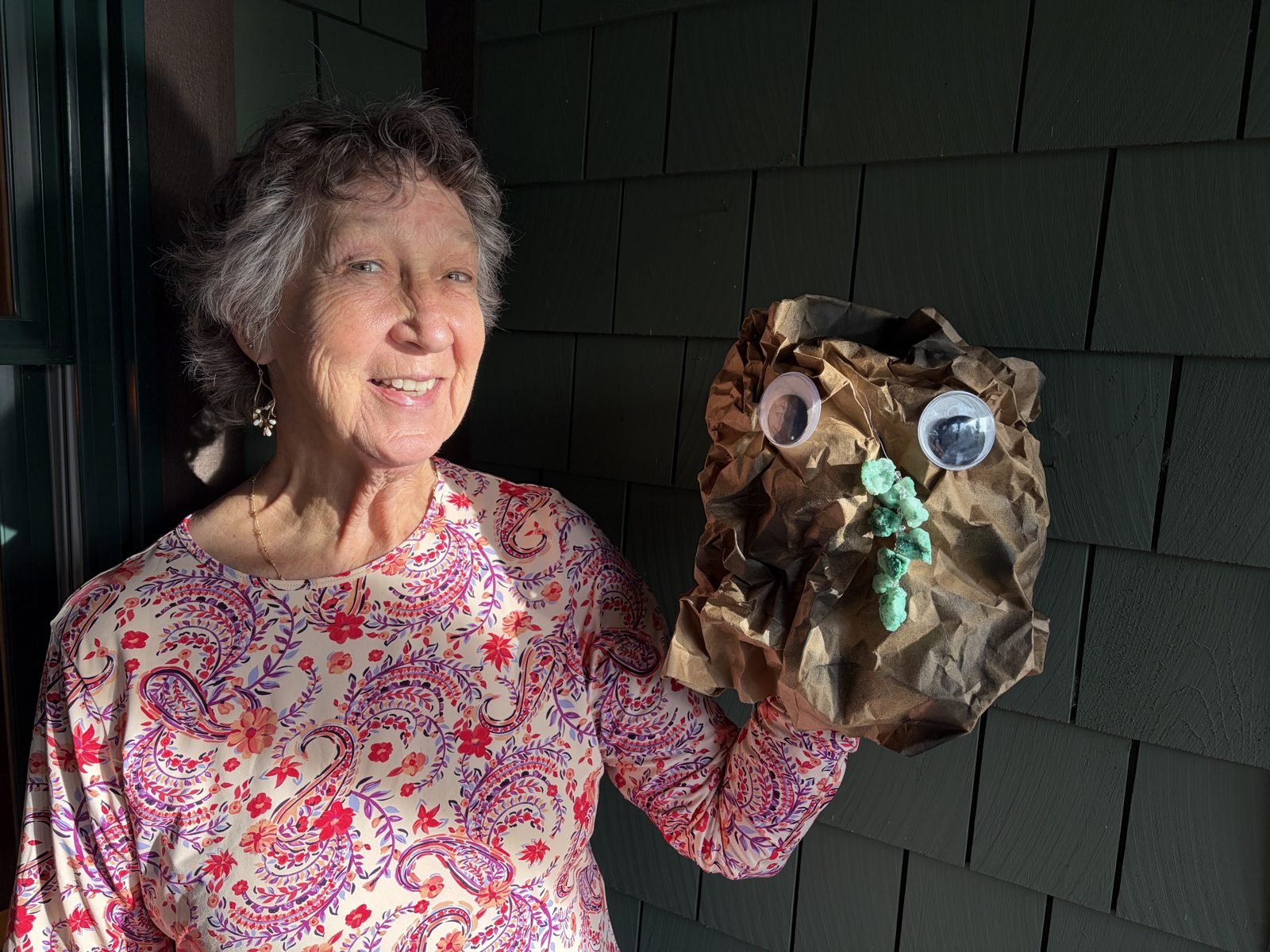 Carrie holding the Metamorphic rock puppet, a crumpled paper bag with green stones glued on